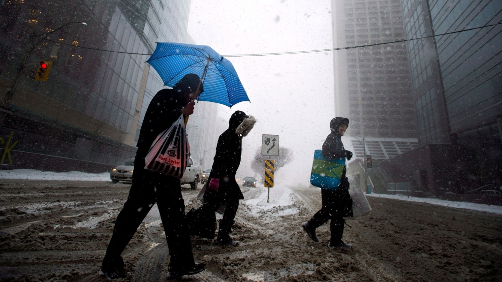  A man uses an umbrella to take cover from the blizzard like conditions in Toronto on Wednesday, March 12, 2014. (Nathan Denette / THE CANADIAN PRESS) 