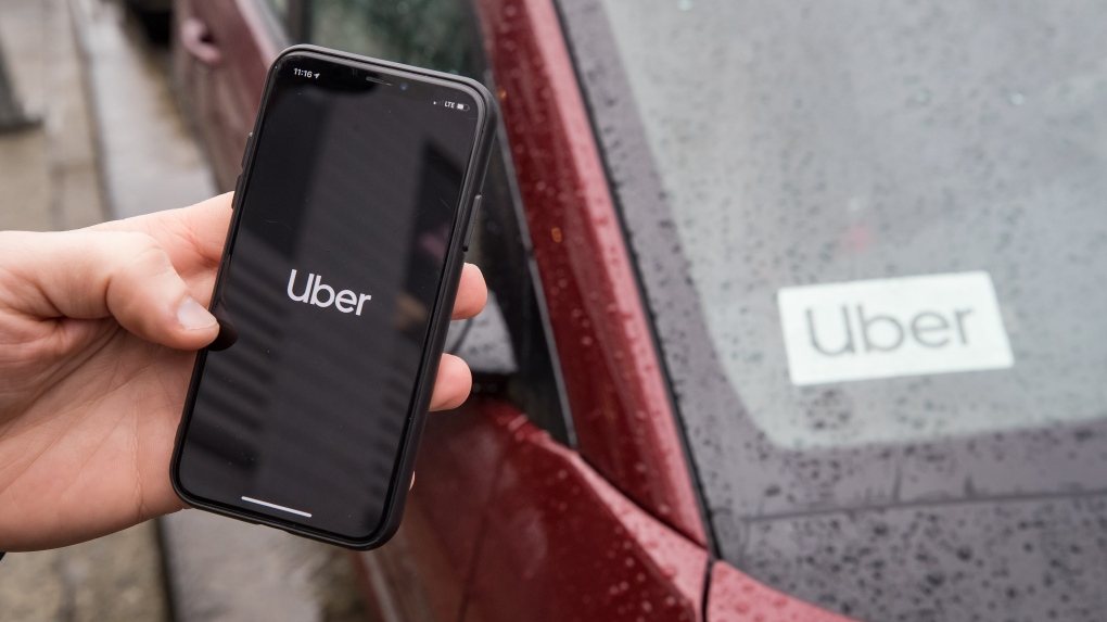 The Uber app is seen on an iPhone near a driver's vehicle after the company launched service, in Vancouver, Friday, Jan. 24, 2020. (THE CANADIAN PRESS/Darryl Dyck) 