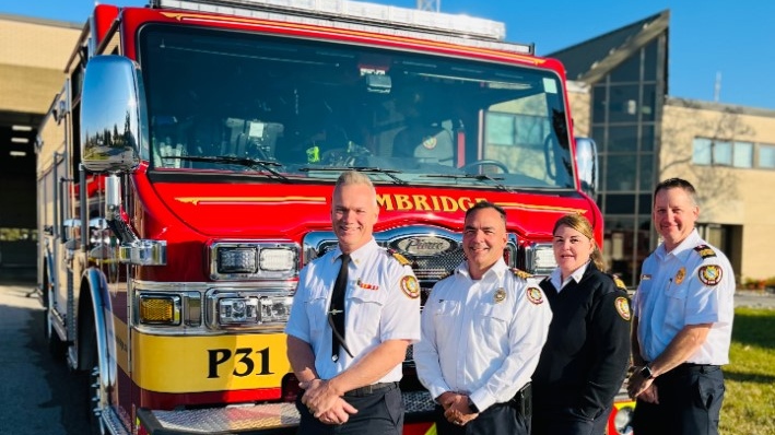Cambridge Fire Chief Rob Martin (far left) in front of one of the city's firetrucks. (Source: Cambridge Fire Department/Twitter)