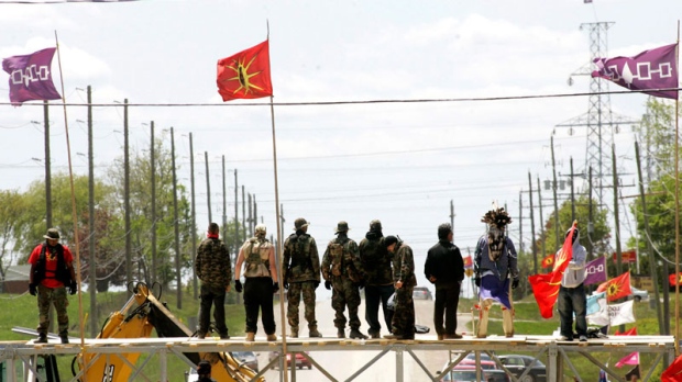 Six Nations protesters stand on top of their barricade moments before taking it down in Caledonia, Ont., near Hamilton on May 23, 2006. (Nathan Denette/THE CANADIAN PRESS)