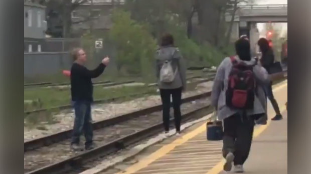 A screen grab of a man standing on tracks