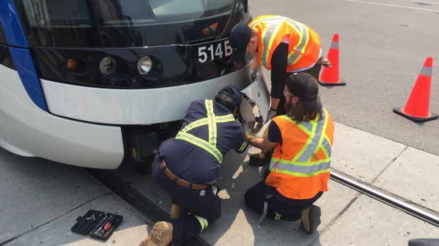 Crews remove a damaged bumper from the LRT