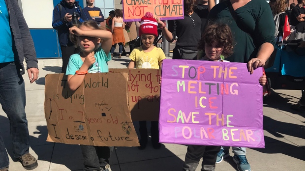 Two children holding climate signs